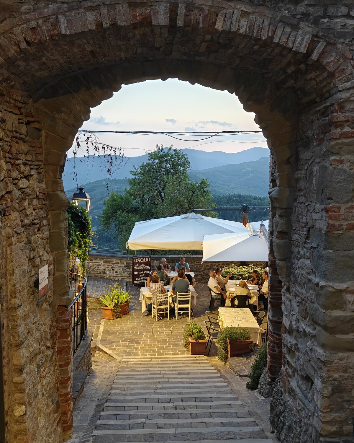 A stone arch and steps opening towards a terrace and the valley in Monte Santa Maria Tiberina