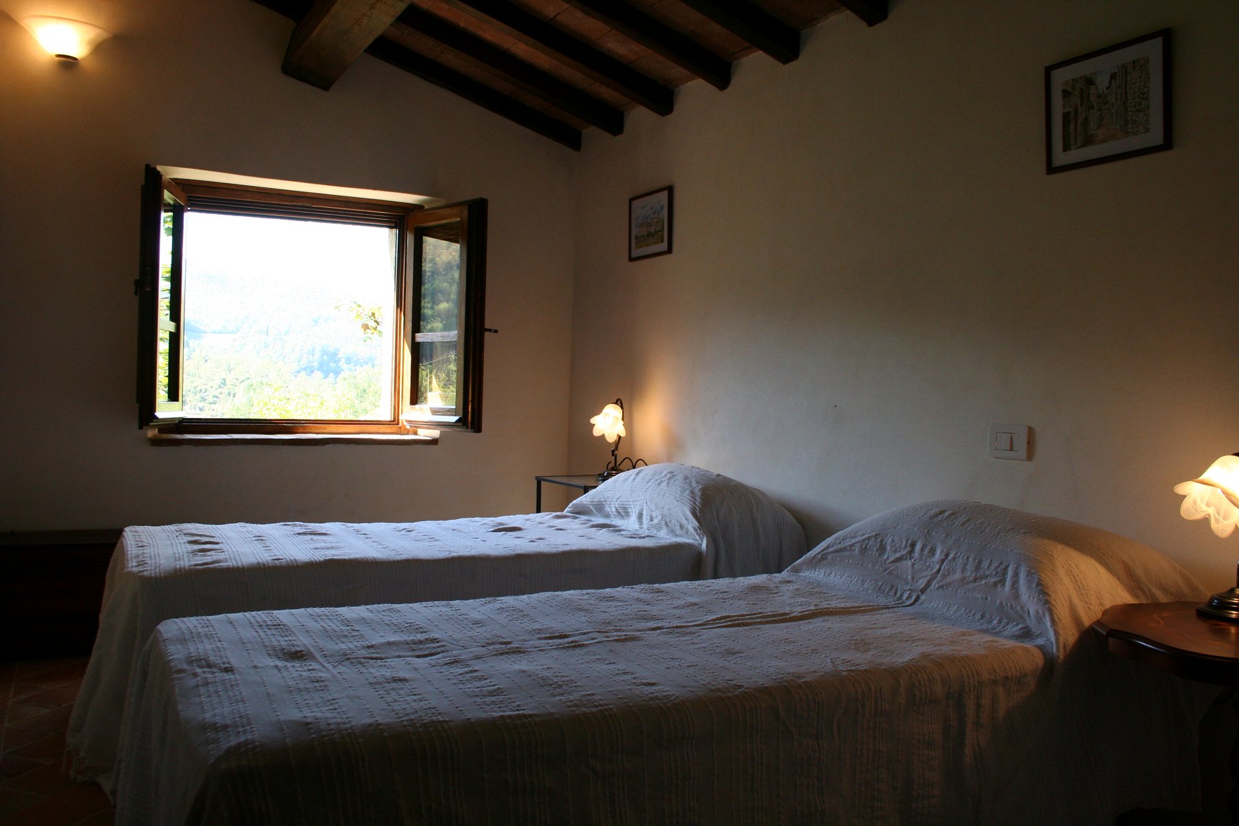 A twin bedroom with a valley view through the open window