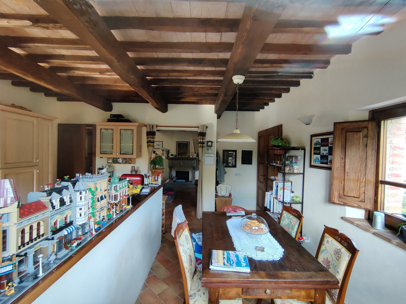 The dining room and kitchen beneath chestnut beams