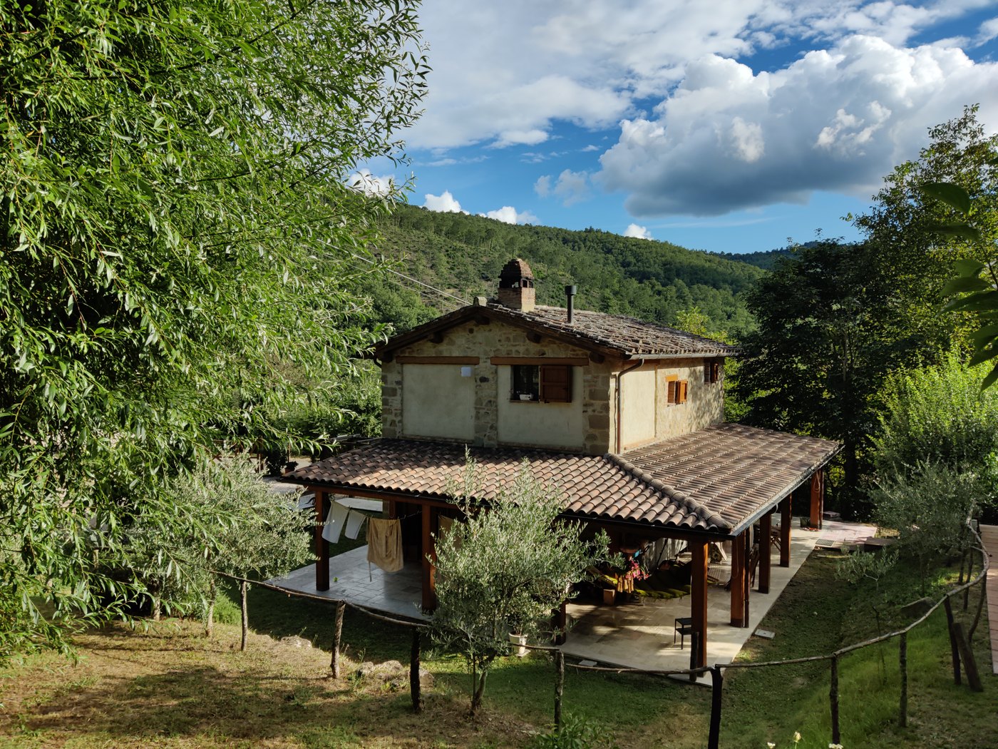 Il Palazzino and its covered pergola among the green hills of the Upper Tiber Valley